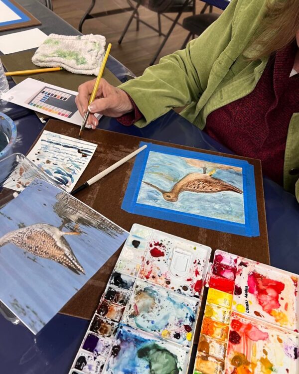A Woman Doing a Watercolor Painting With a Reference Image